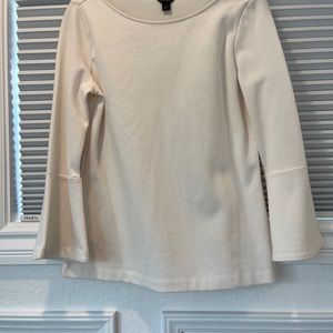 Cream jersey top with bell sleeves.